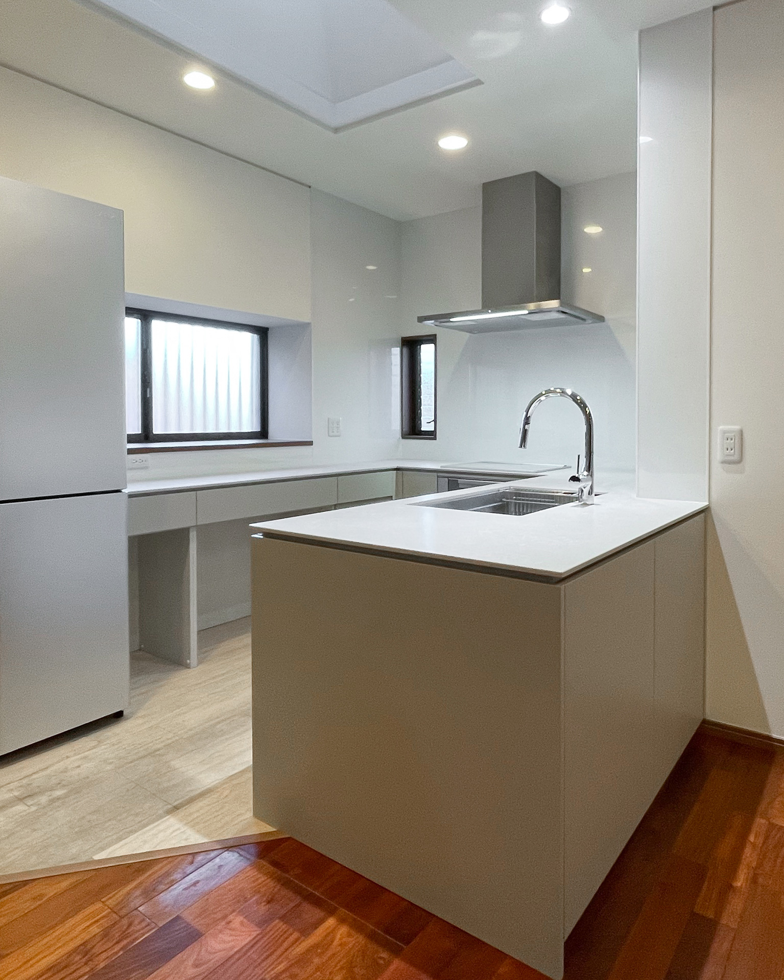 やさしいグレージュのコの字キッチン