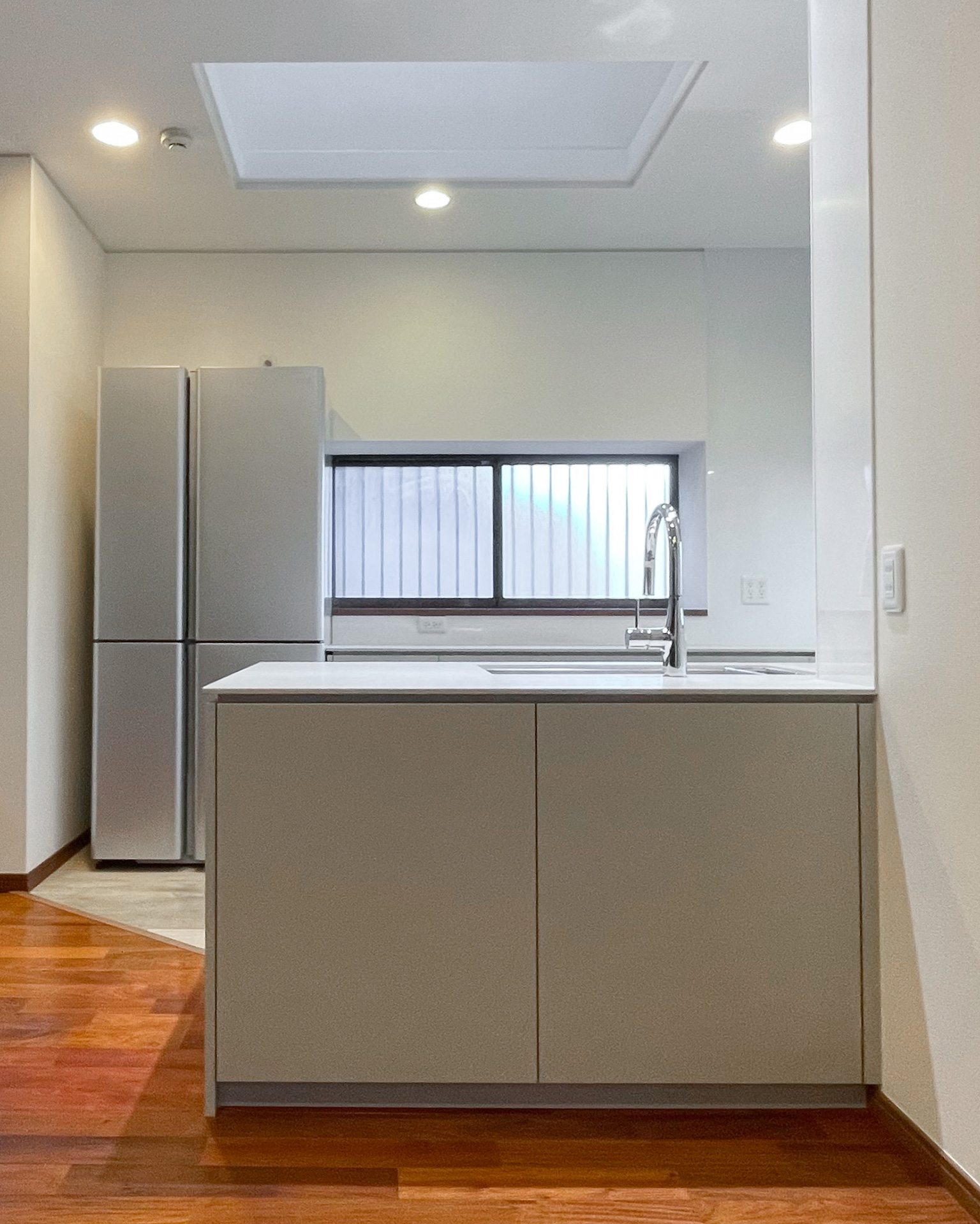 写真：やさしいグレージュのコの字キッチン