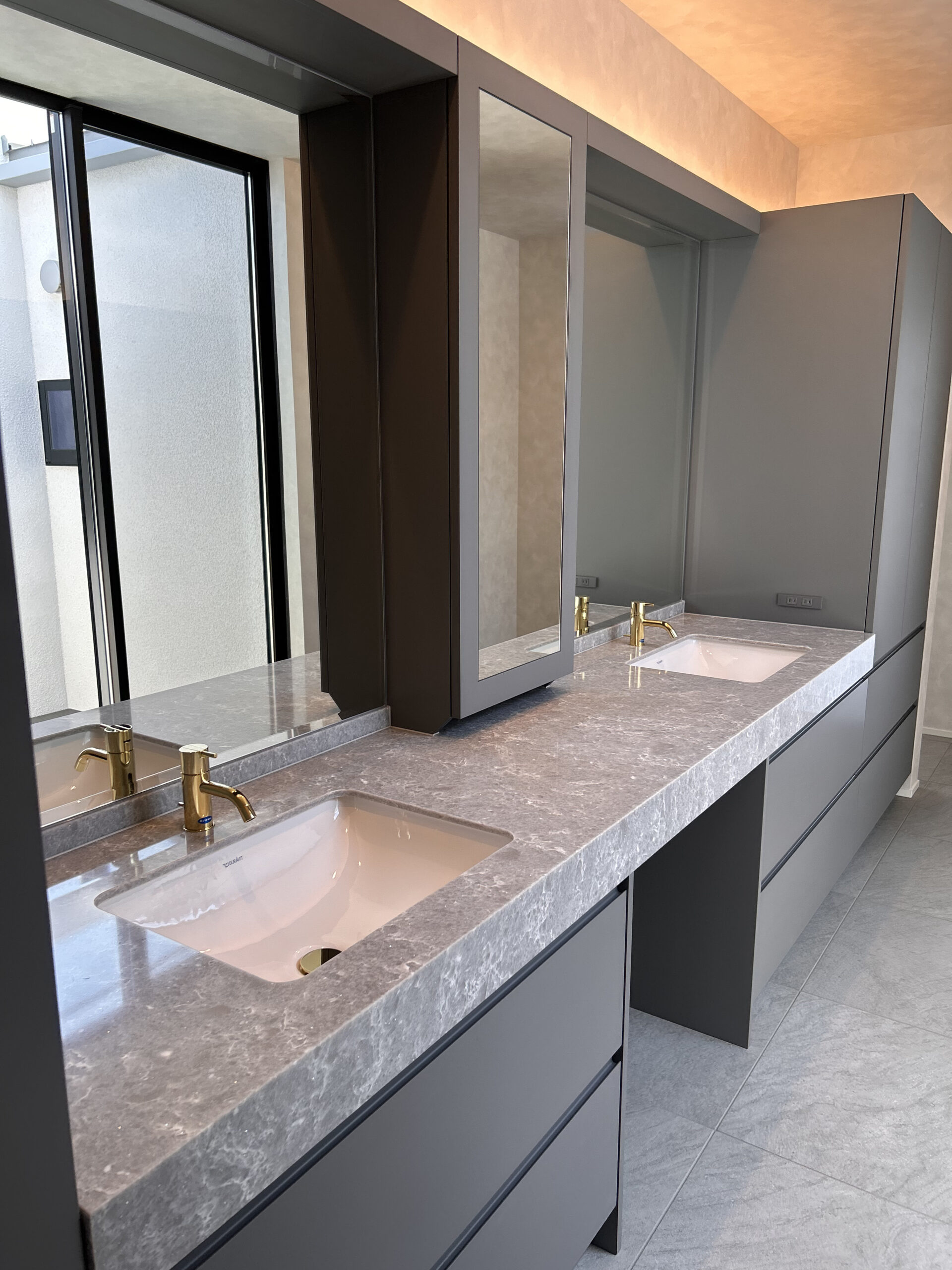 光を受け止めるグレートーンの洗面空間